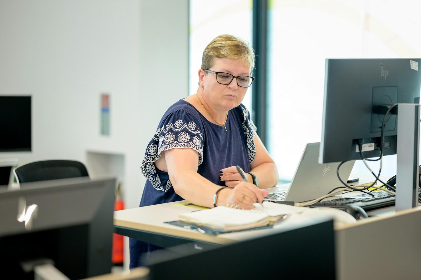 Účtovníčka pracuje s dokladmi pri počítači